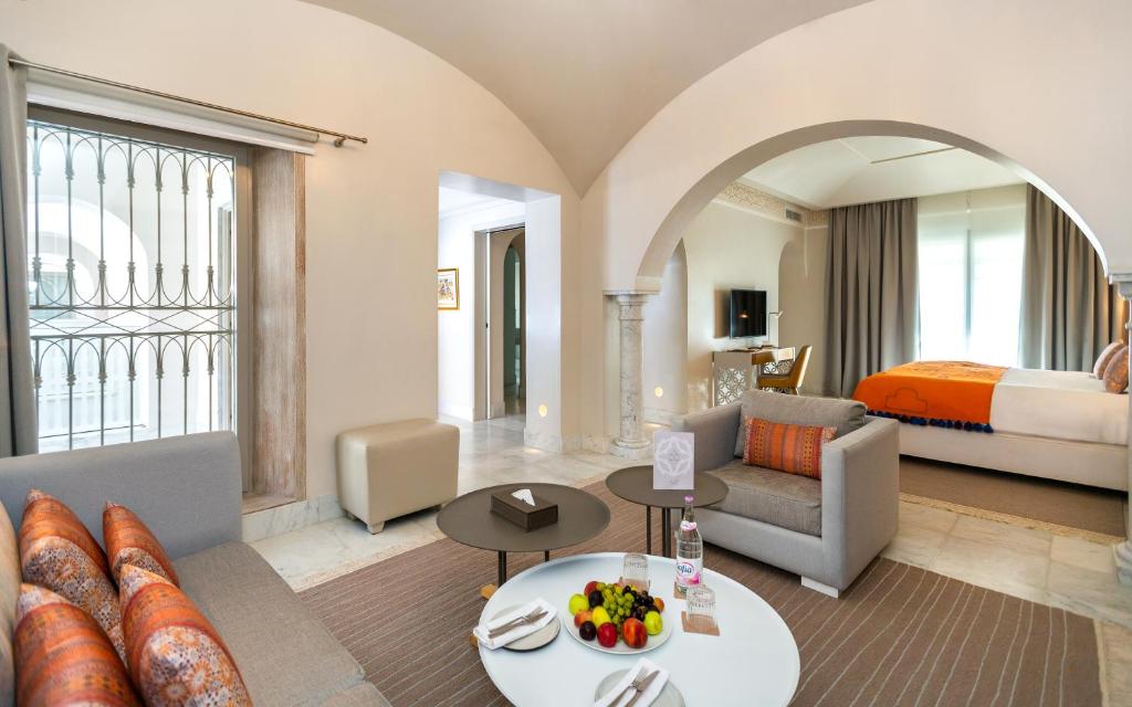 a living room with a couch and a bed and a room at Dar El Jeld Hotel and Spa in Tunis