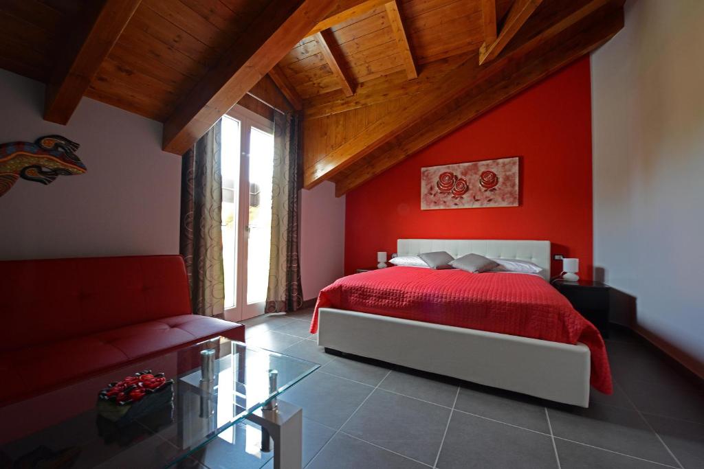 Dormitorio rojo con cama y ventana en I Fiori di Malpensa, en Ferno