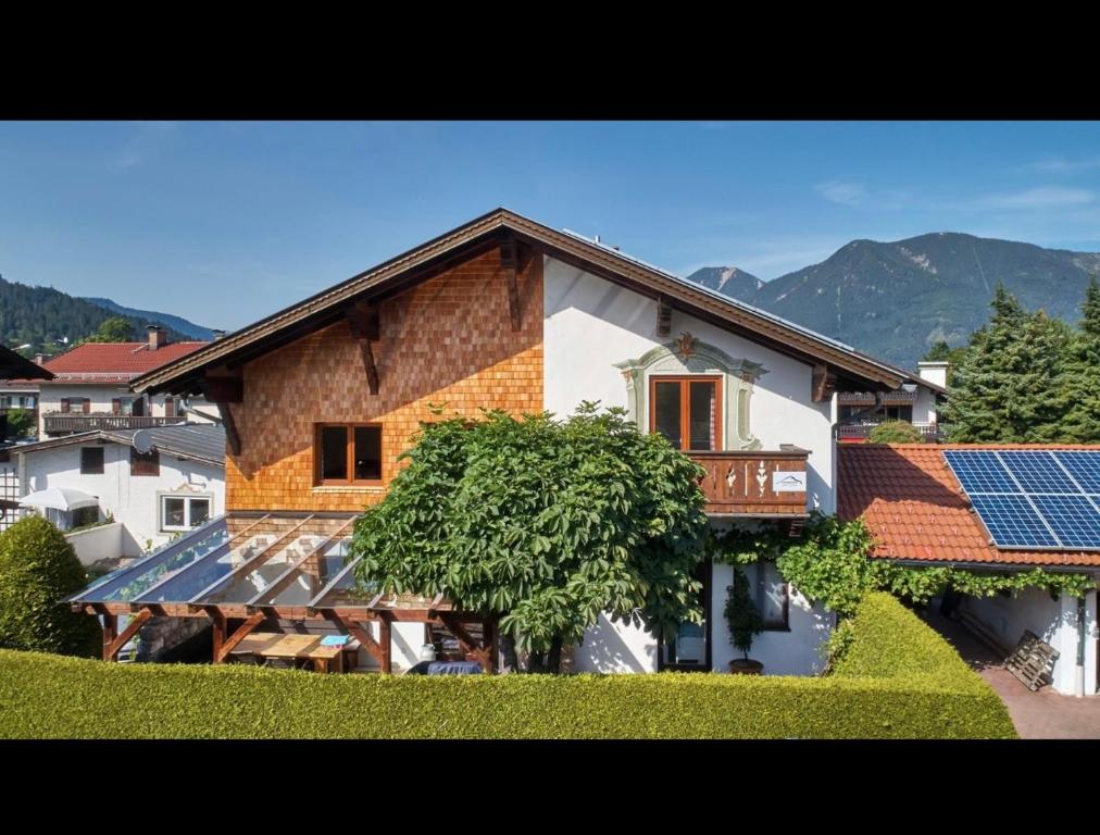 a house with solar panels in front of it at Ferienwohnung zum Servus in Garmisch-Partenkirchen