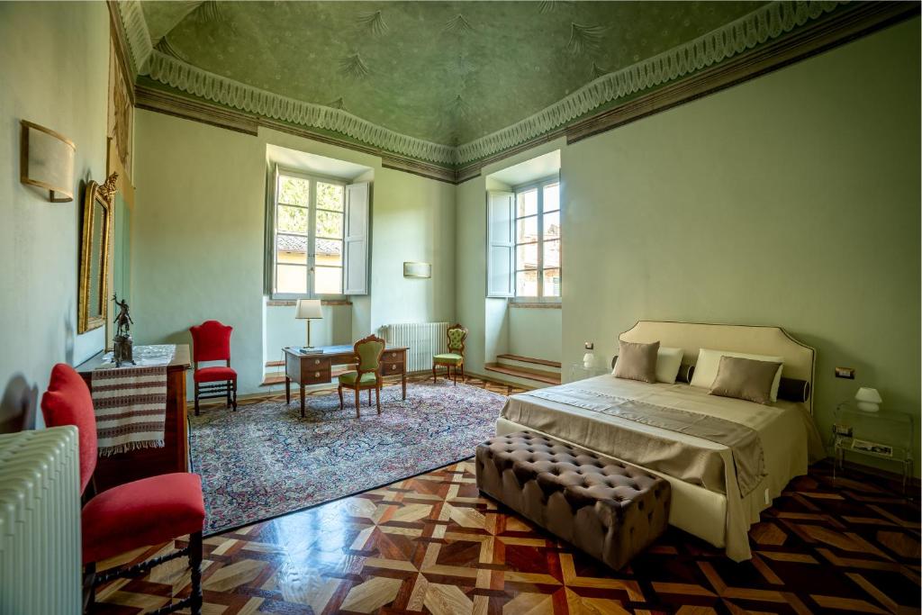 una camera con letto, tavolo e sedie di Historical Renaissance Palace a Montepulciano