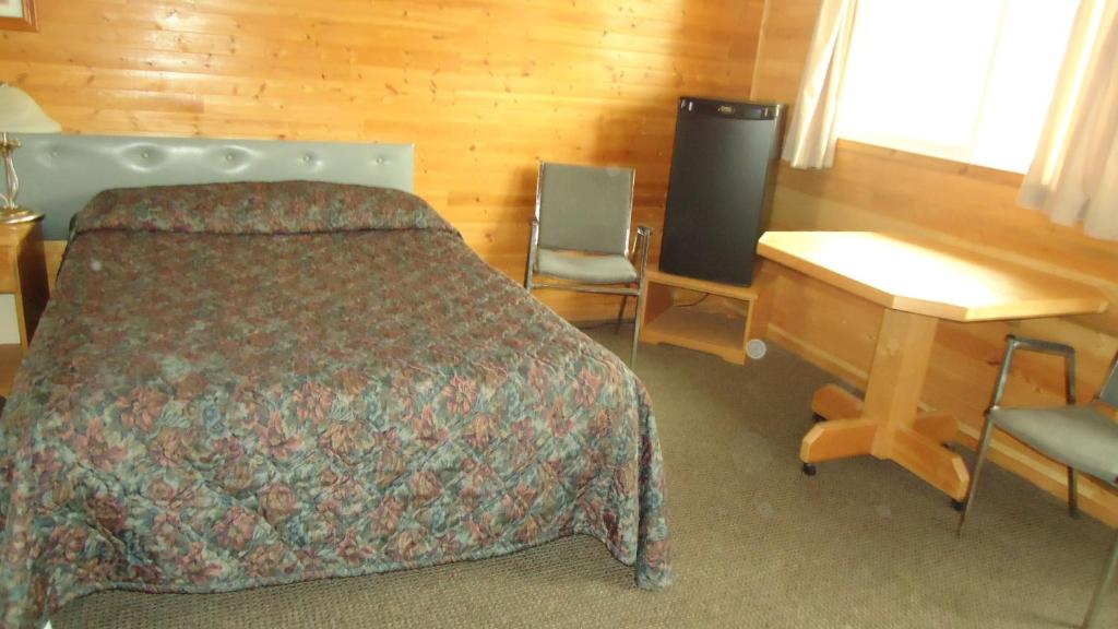 1 dormitorio con cama, escritorio y escritorio en Dreamland Motel, en Moose Jaw