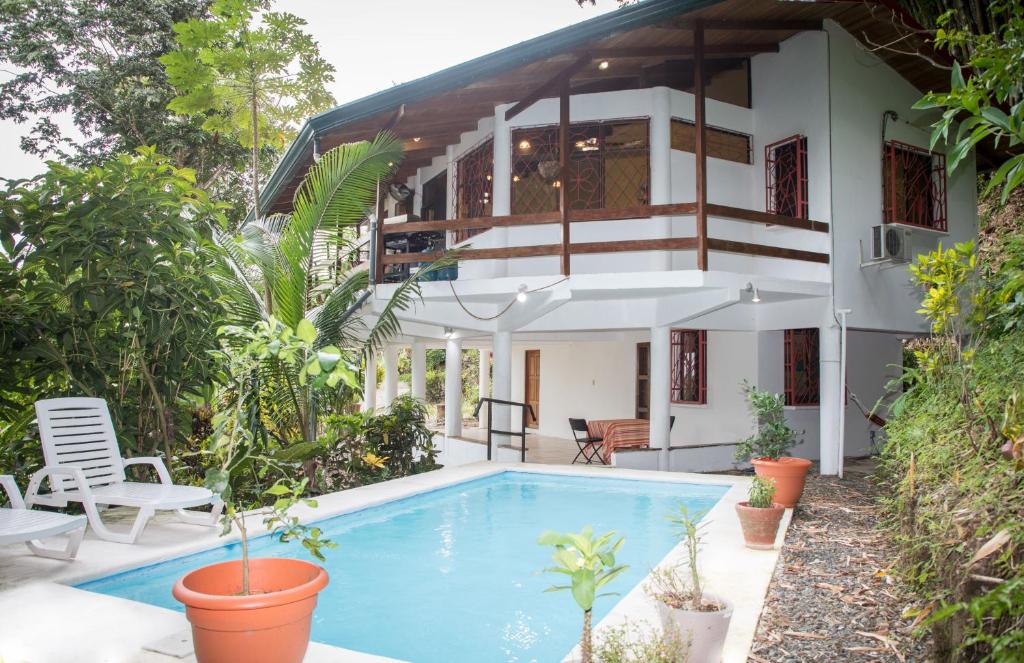 uma casa com uma piscina em frente em Kiskadee Casa em Quepos
