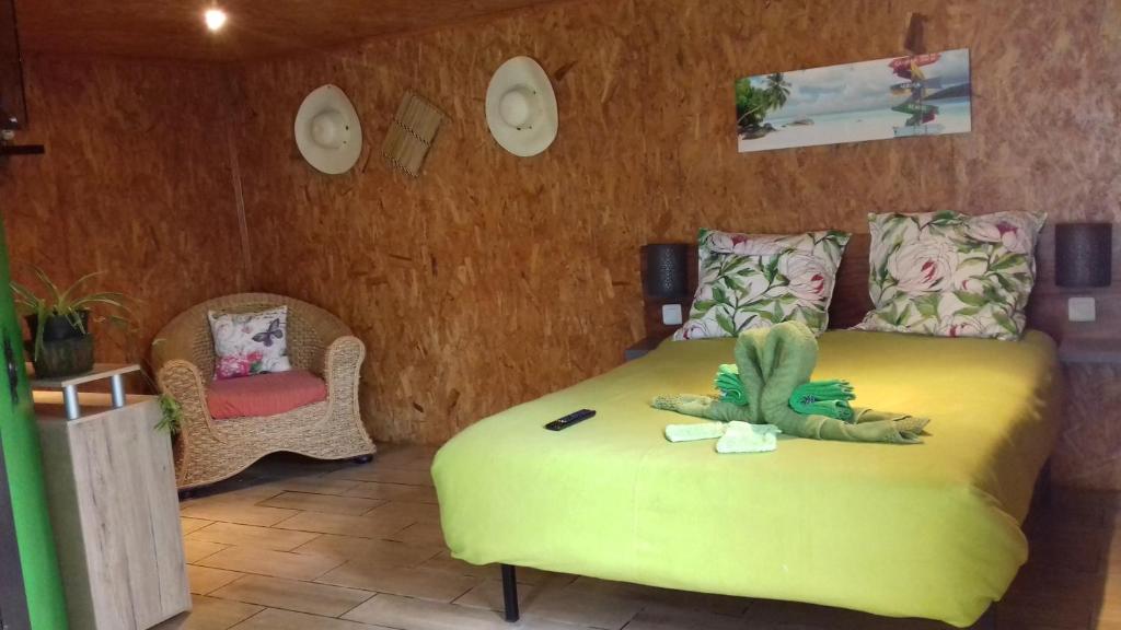 ein Schlafzimmer mit einem Bett mit einem ausgestopften Tier darauf in der Unterkunft Ferme Lebon Papillon le chalet kayamb in Le Tampon