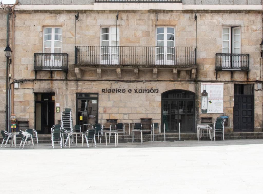 um edifício com mesas e cadeiras numa rua em Piso Top en Plaza Mayor em Ribadavia