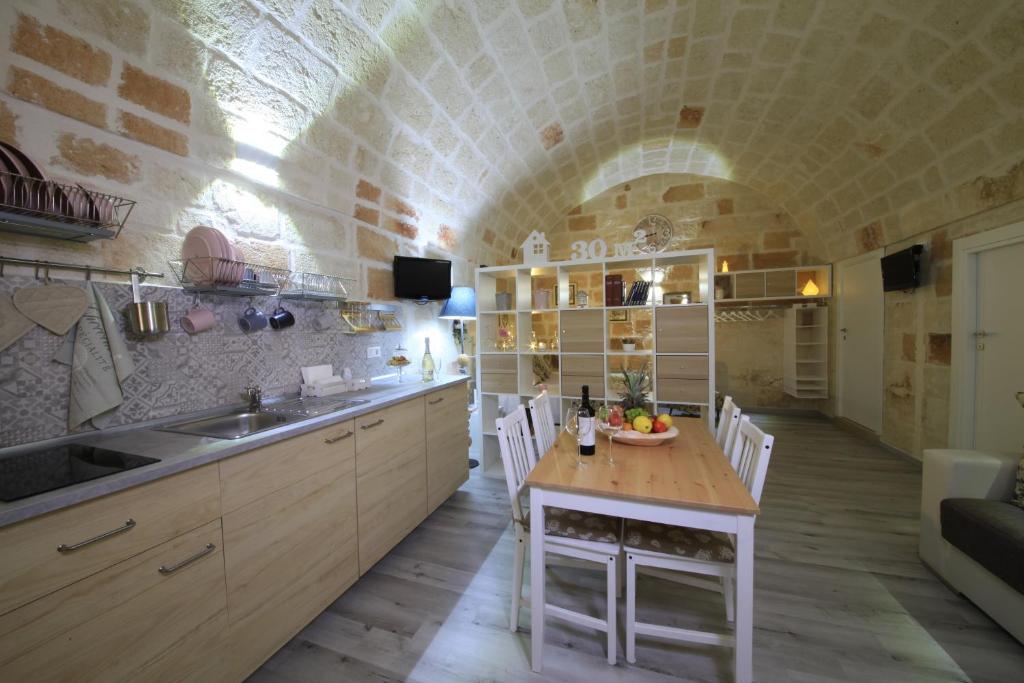 a kitchen with a table in a room with an archway at 30 METRI QUADRATI in Monopoli