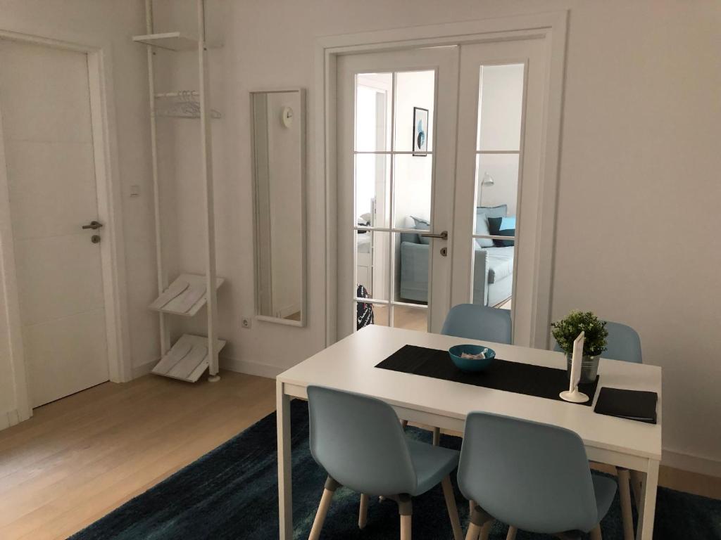 comedor con mesa blanca y sillas en Design District Apartments, en Zagreb