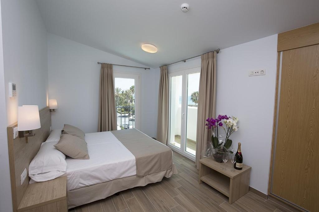 a white bedroom with a bed and a window at Ocean Lounge in Altea