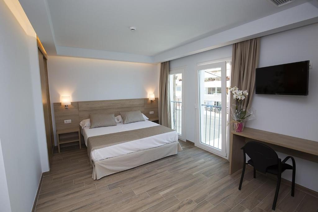 a hotel room with a bed and a television at Ocean Lounge in Altea