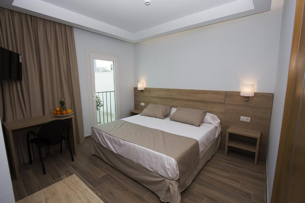 a bedroom with a bed and a desk and a window at Ocean Lounge in Altea