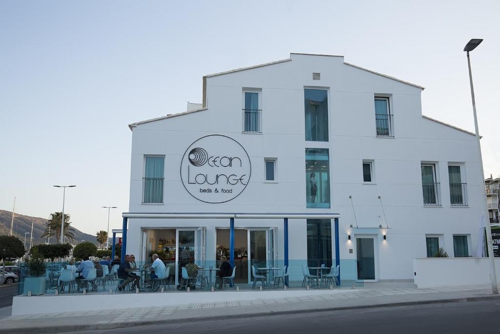a white building with people sitting outside of it at Ocean Lounge in Altea