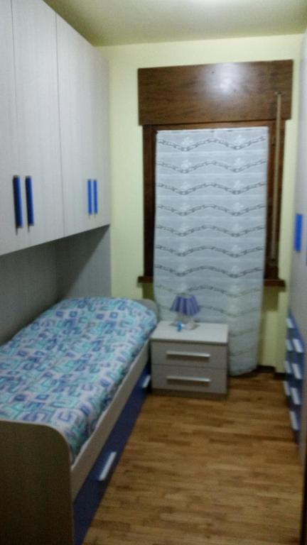una piccola camera con letto e comodino di Habitat Dolomiti-Cadore a Pieve di Cadore