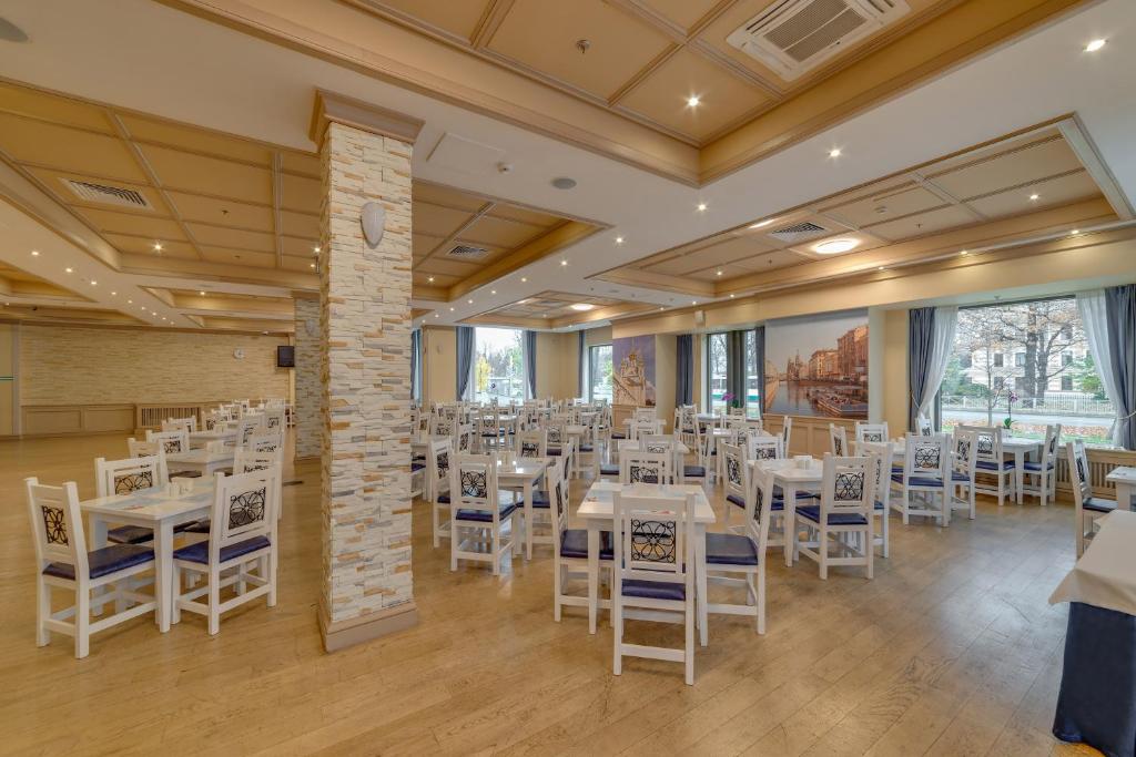 a banquet hall with white tables and chairs at New Peterhof Hotel in Petergof
