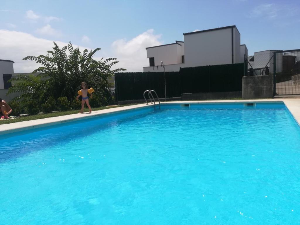 a girl in a bikini standing next to a swimming pool at Villa Dalia in Suances