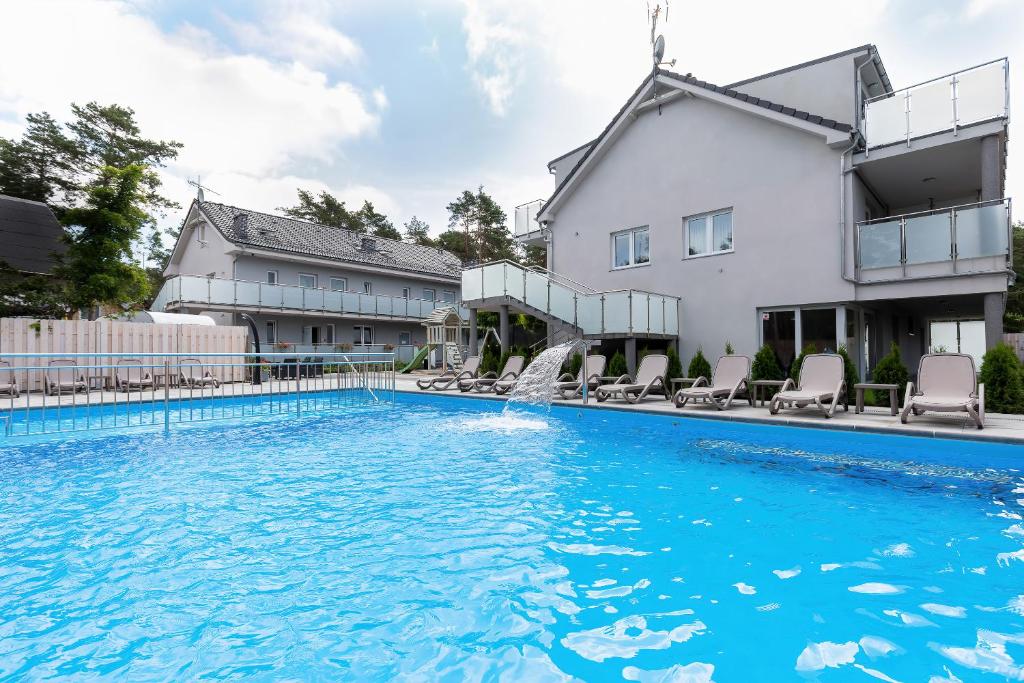 a swimming pool with a fountain in the middle of a building at Apartamenty Angela in Pobierowo