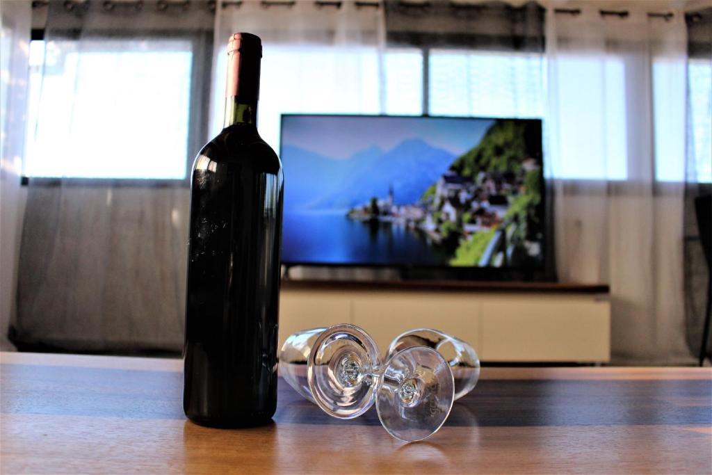 a bottle of wine and glasses on a table with a television at אירוח נוף הרים in Safed