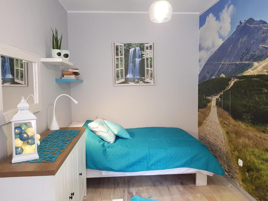 - une chambre avec un lit et une peinture murale dans l'établissement Apartamenty Klimacik, à Karpacz