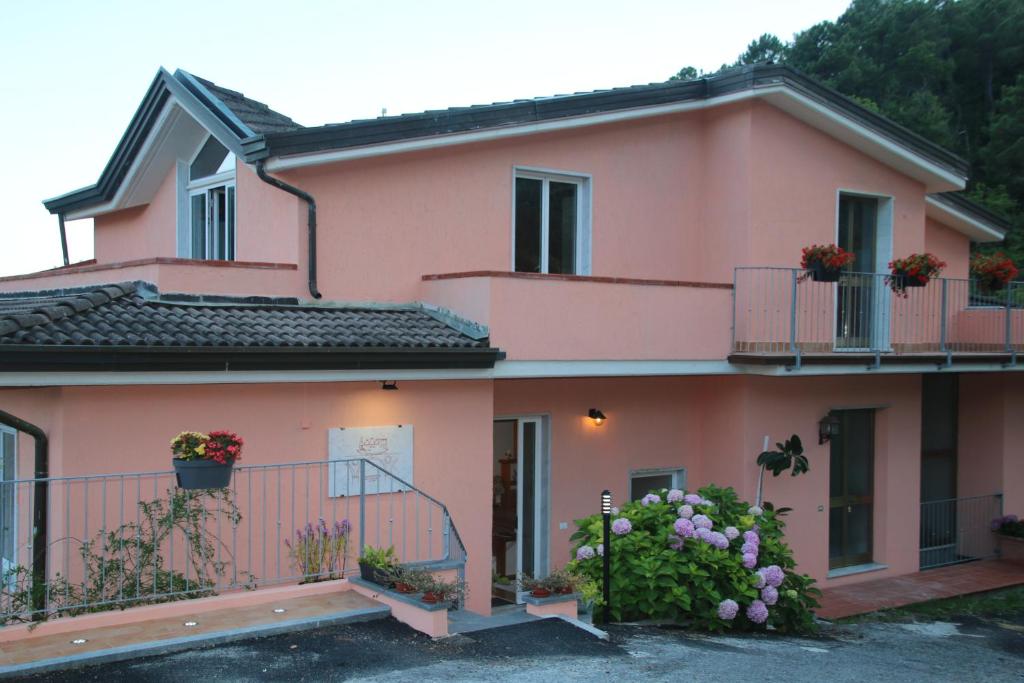 una casa rosa con fiori sui balconi di B & B LA MARMIFERA a Carrara