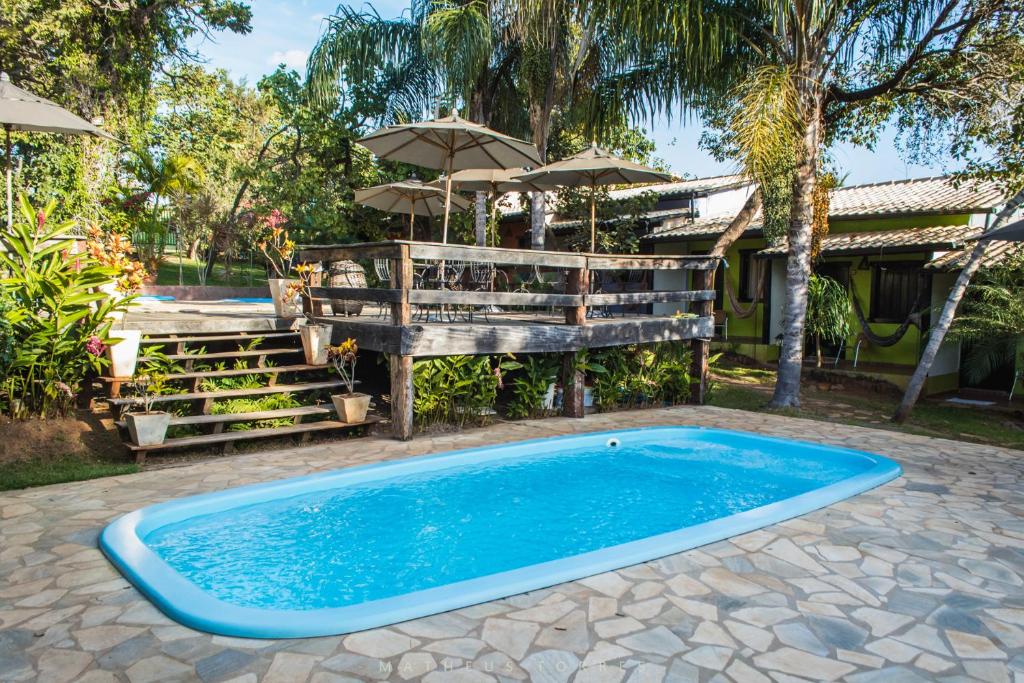 una piscina en un patio con una casa en Pousada Anauê Cipó, en Serra do Cipo