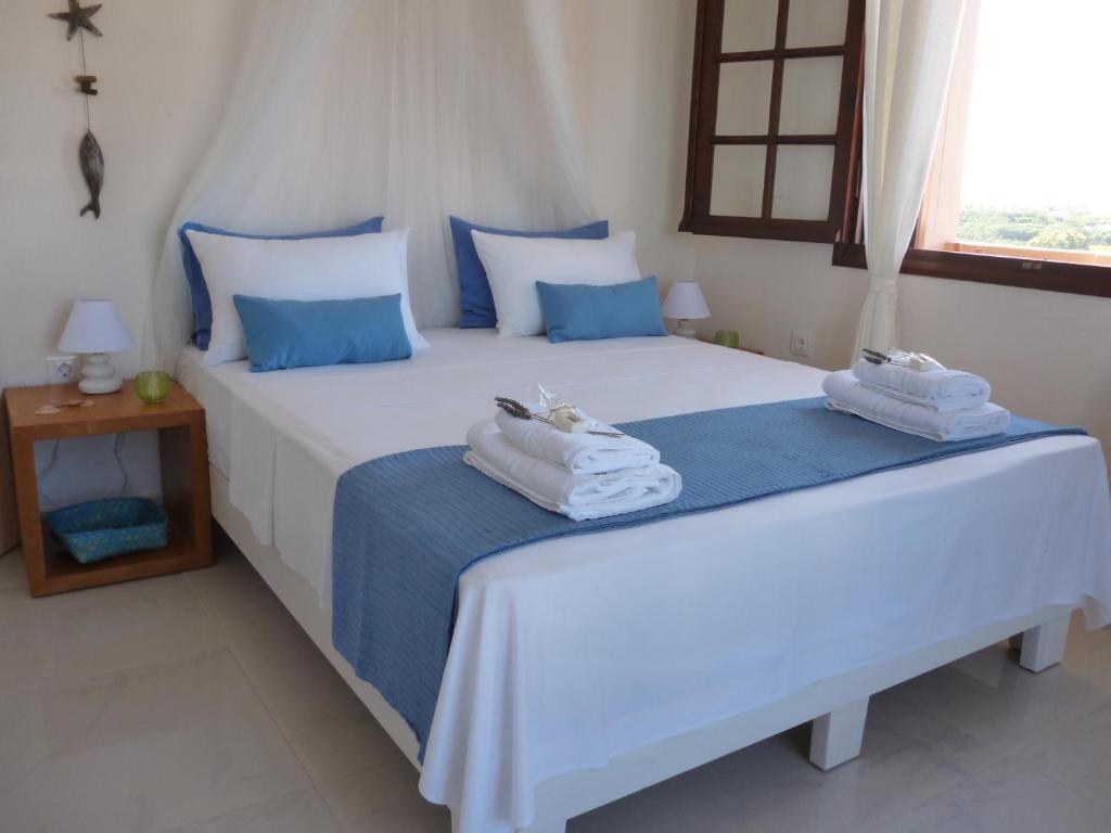 a bedroom with two beds with towels on them at Romanza in Kalamaki