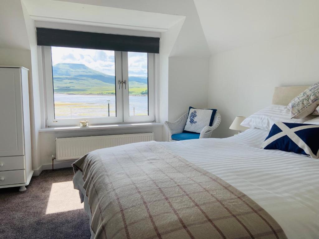 a bedroom with a bed and a large window at Easan Dubh in Dunvegan