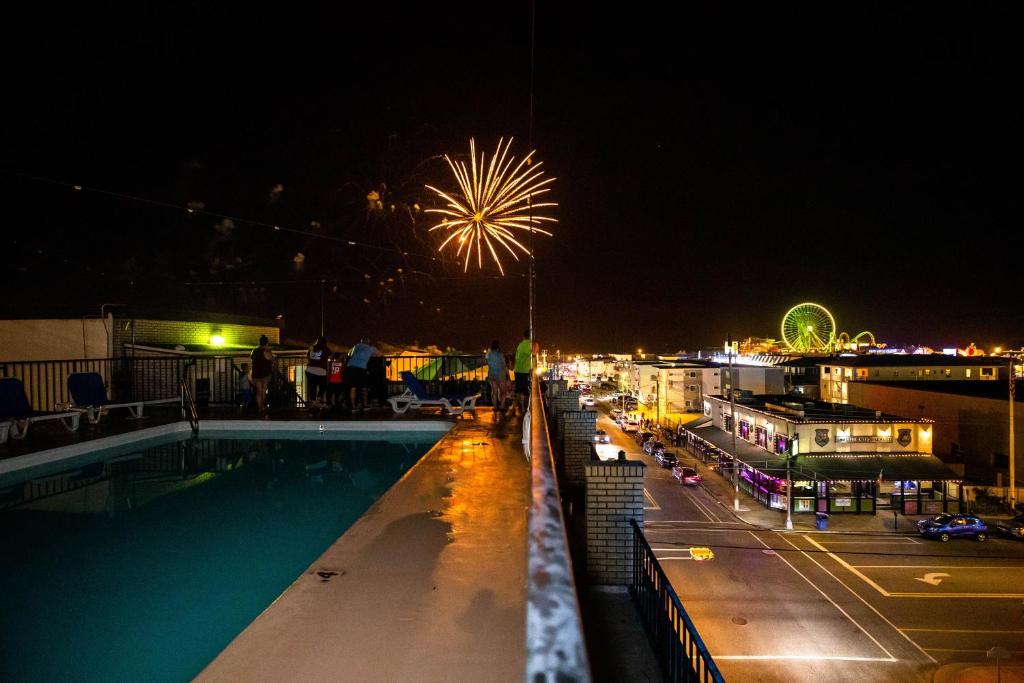 a view of a pool and fireworks at night at Premiere Motel in Wildwood