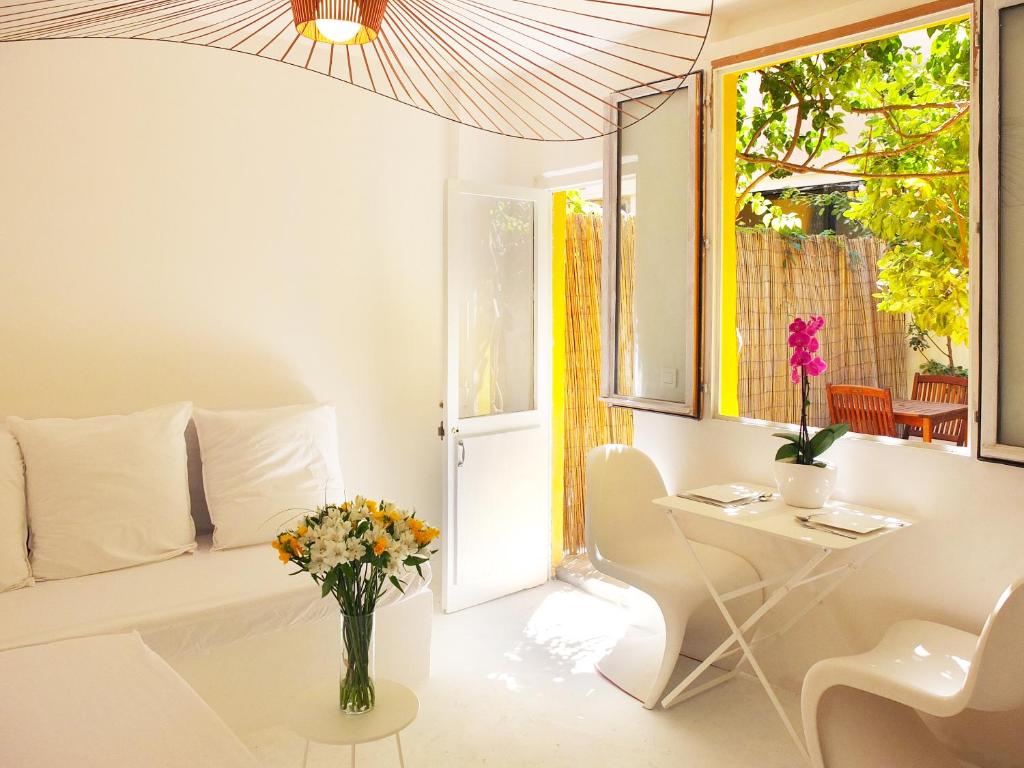 een witte woonkamer met een vaas met bloemen op een tafel bij La maison jaune in Sète