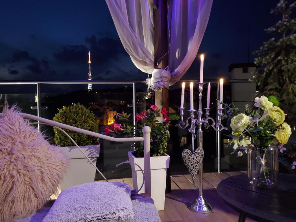een balkon met een tafel met kaarsen en bloemen bij Apart-terrace on Baker Street in Lviv