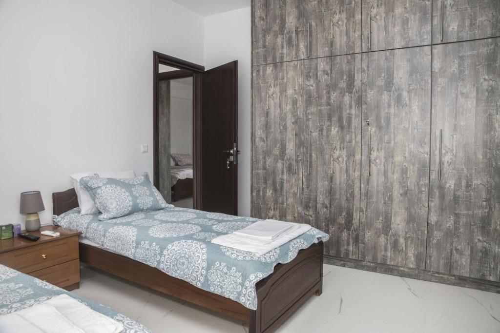 1 dormitorio con 1 cama y pared de madera en Villa Miron en Kamilari