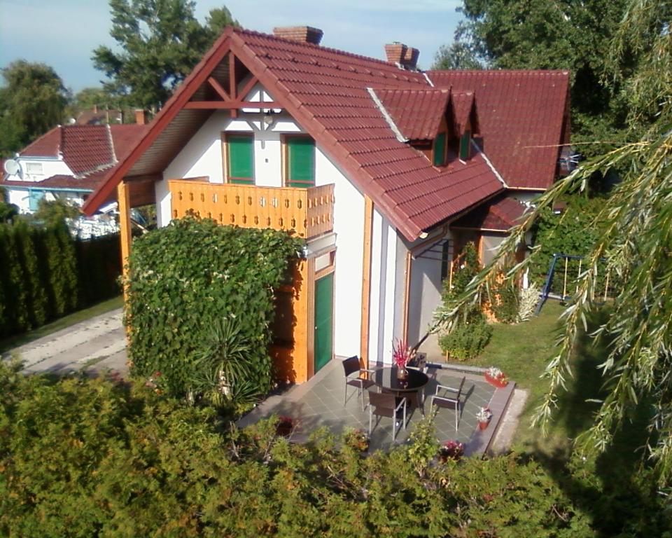 una pequeña casa blanca con techo rojo en Anna Üdülőház, en Balatonberény