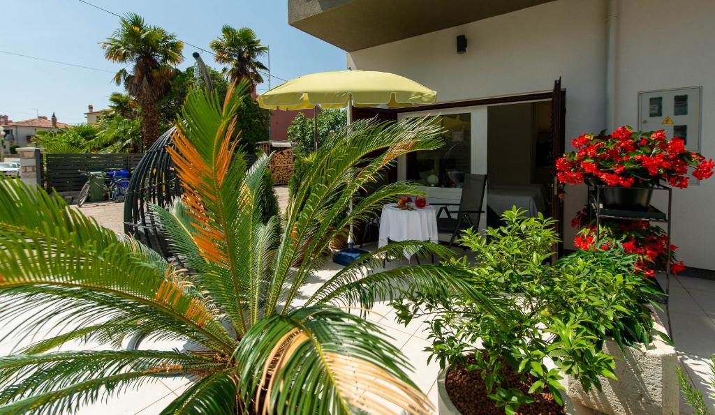 a patio with a table with flowers and an umbrella at Apartments Medora in Rovinj