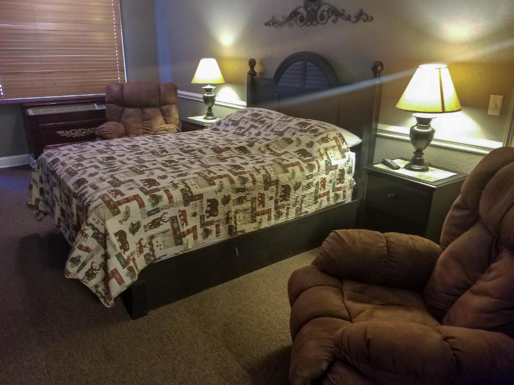 a bedroom with a bed and a chair and lamps at Lily Pad Suites in Andrews
