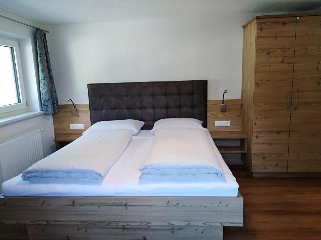 カップルにあるLeonards Apartsのベッドルーム1室(大型ベッド1台、木製ヘッドボード付)