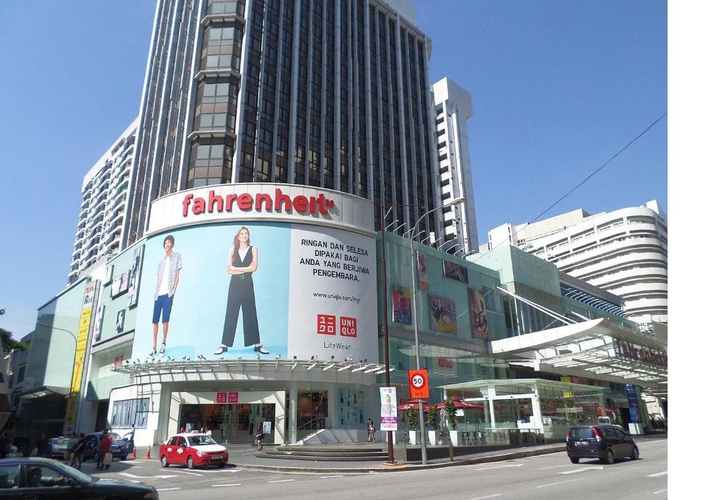 a city street with a building with a large advertisement for a waiter at #PERFECT# Location BUKIT BINTANG Apartment in Kuala Lumpur