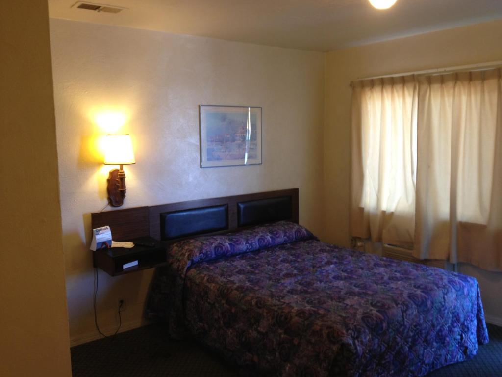 a hotel room with a bed and a lamp at Budget Inn in Green River