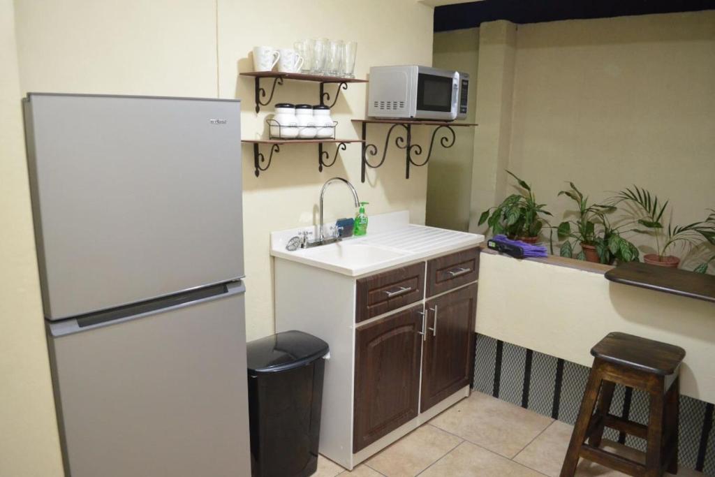 uma cozinha com um lavatório e um frigorífico em #5 Private room close to Airport em Alajuela