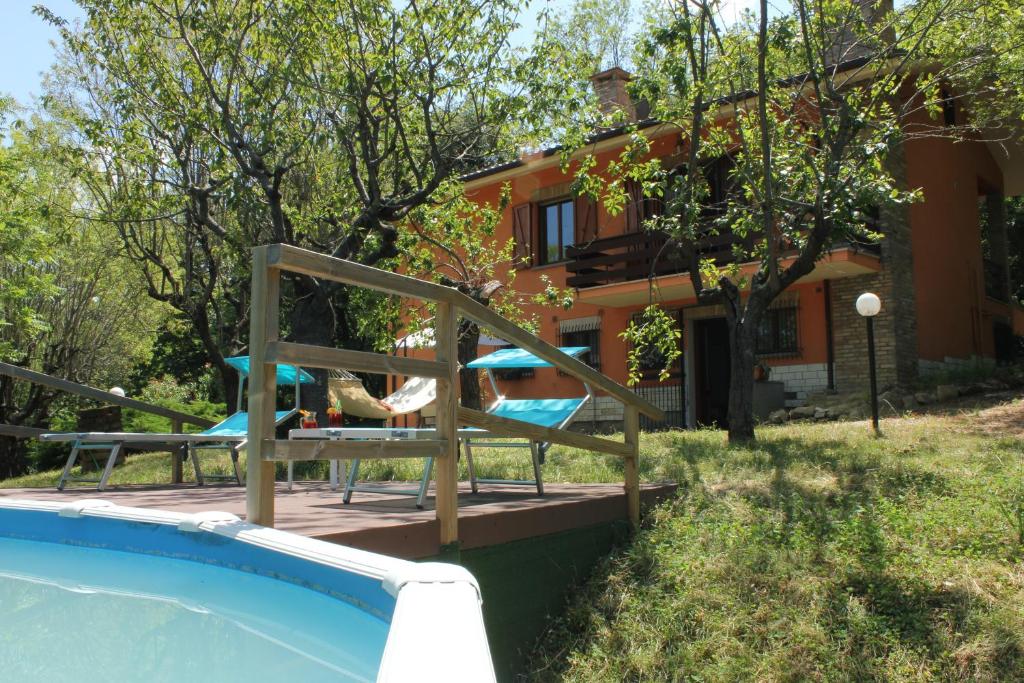 a house with a swimming pool in front of a house at Villa Mombaroccio le colline di Pesaro tra mare e natura in Mombaroccio