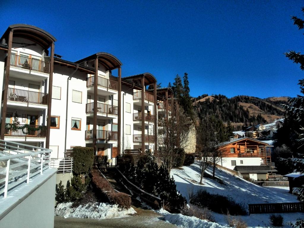 um grande edifício com neve no chão em frente em Apartment Sissi em Badia