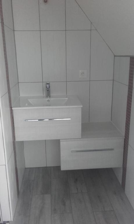 a white bathroom with a sink and a mirror at Chambre d&#39;hôte du HOUSSAY in Valennes