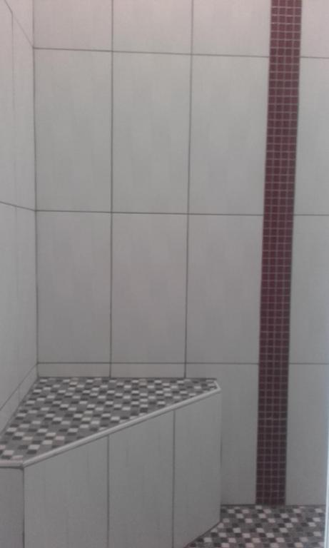 a white tiled kitchen with a stove top oven at Chambre d&#39;hôte du HOUSSAY in Valennes