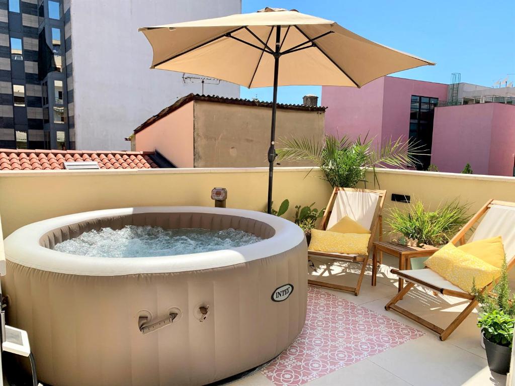 a hot tub on a balcony with an umbrella at Apartment Shiny Love in Split