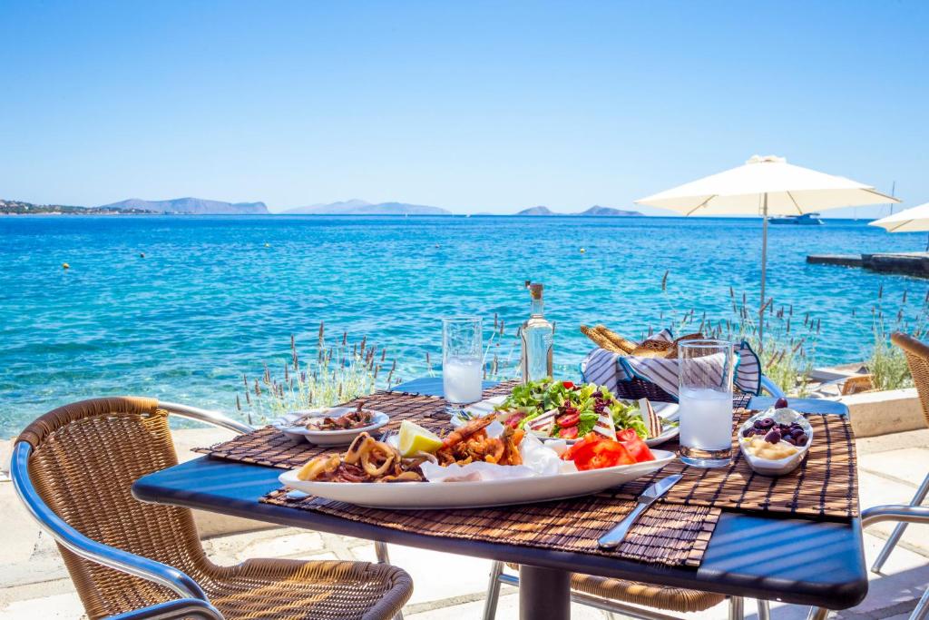 a picnic table with a plate of food on the beach at Spetses Hotel in Spetses