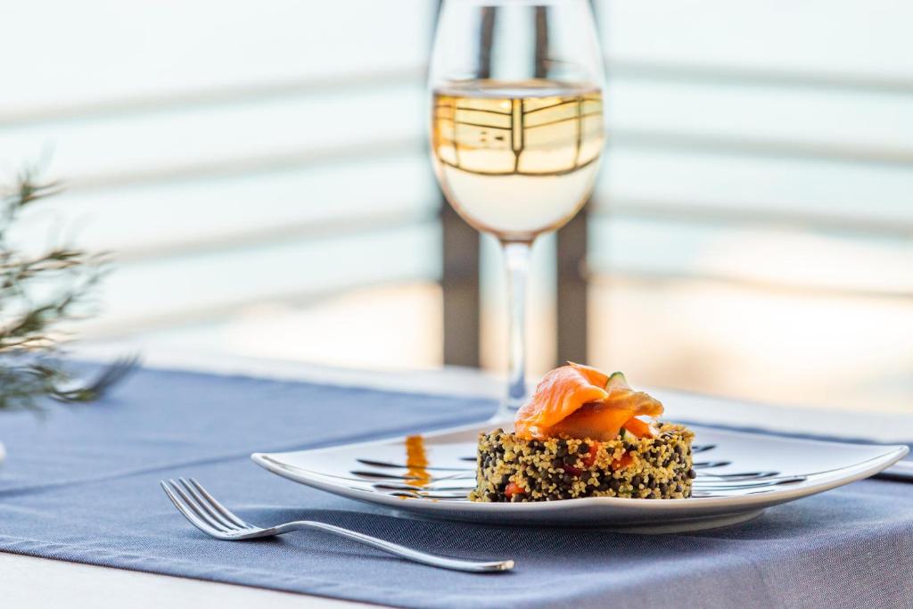 a plate of food on a table with a glass of wine at Spetses Hotel in Spetses
