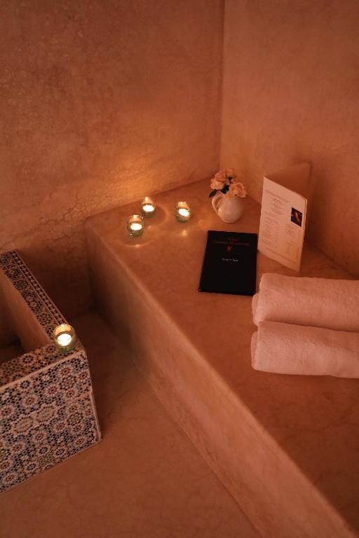 bagno con vasca, candele e asciugamani di Riad l'Oiseau du Paradis a Marrakech