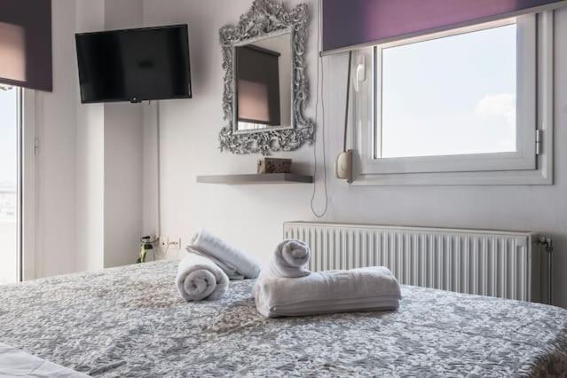 um quarto com uma cama com toalhas e um espelho em Sea View Maisonette in Chania em Chania