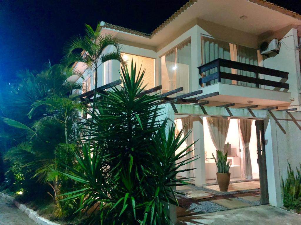 uma casa branca com palmeiras em frente em Villa Bella Vista em Cabo Frio