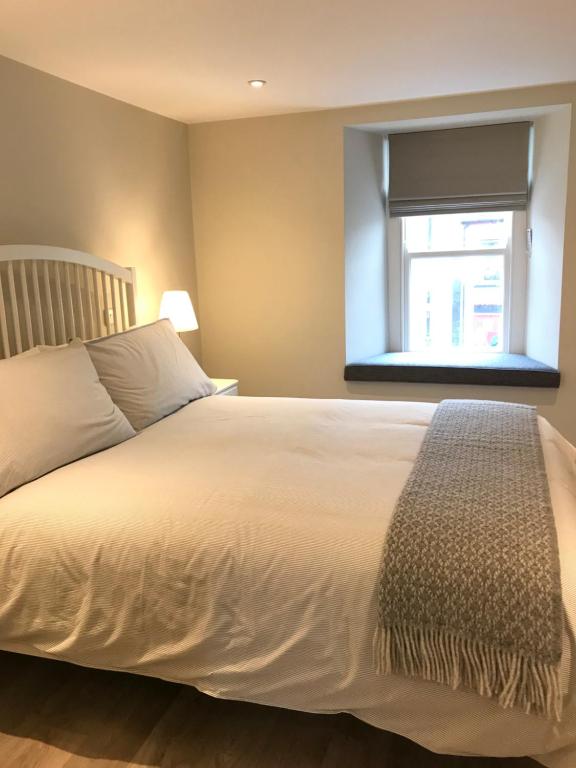 a bedroom with a white bed and a window at Bush House Accommodation - The Diamond in Bushmills