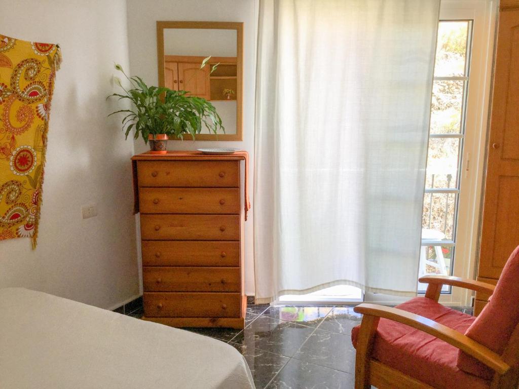 Un dormitorio con un tocador y una ventana con una planta. en Casa de Amig@s en Santa Cruz de la Palma, en Santa Cruz de la Palma
