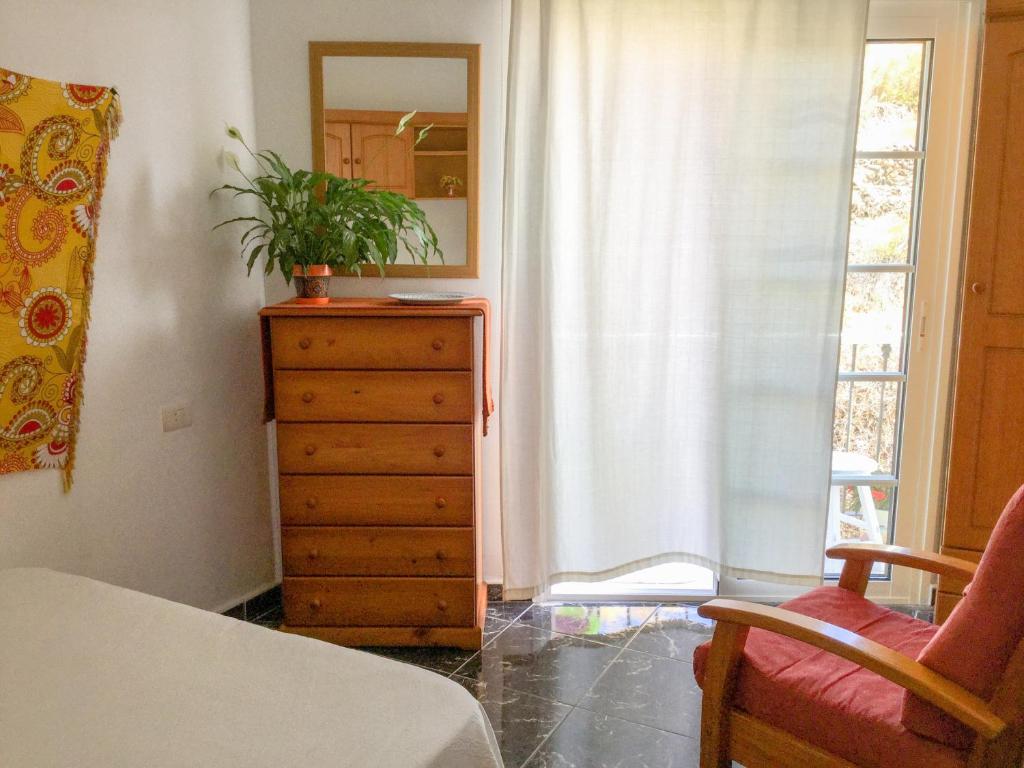 a bedroom with a dresser and a window with a plant on it at Casa de Amig@s en Santa Cruz de la Palma in Santa Cruz de la Palma