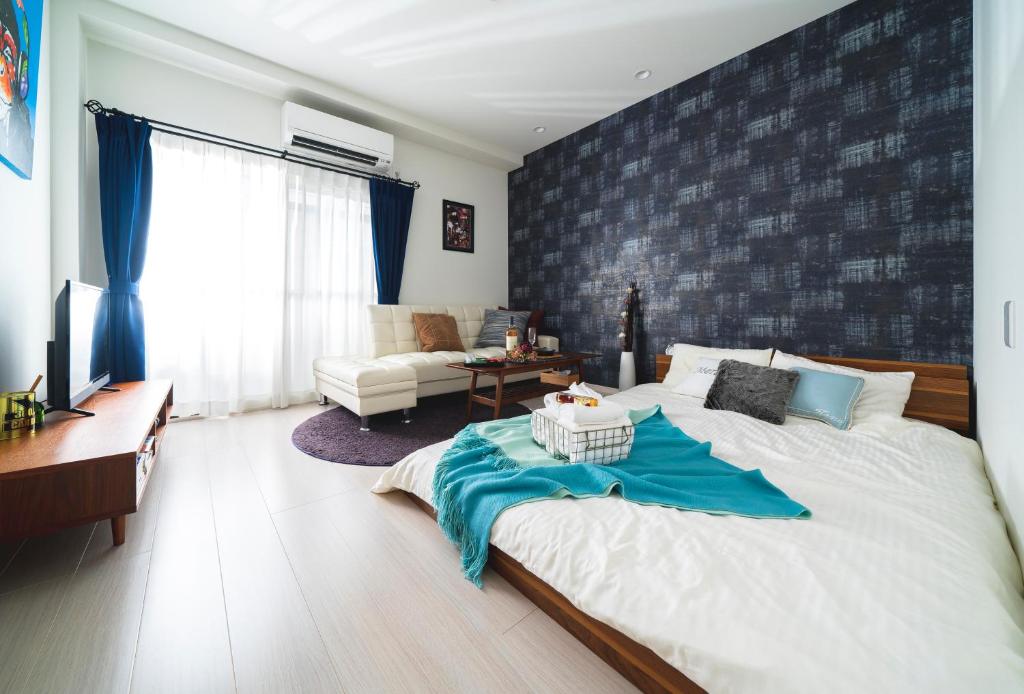 a bedroom with a large bed and a living room at K&K Apartment Kita-Akabane #202 in Tokyo