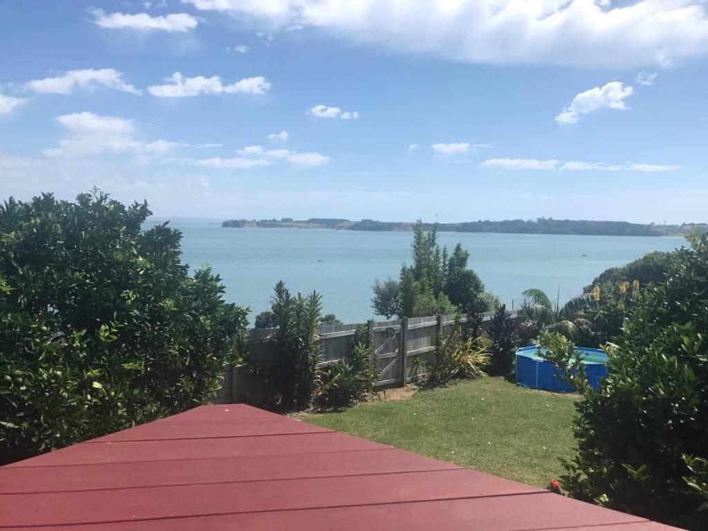 a red walkway with a view of the water at Studio with water views in Omokoroa